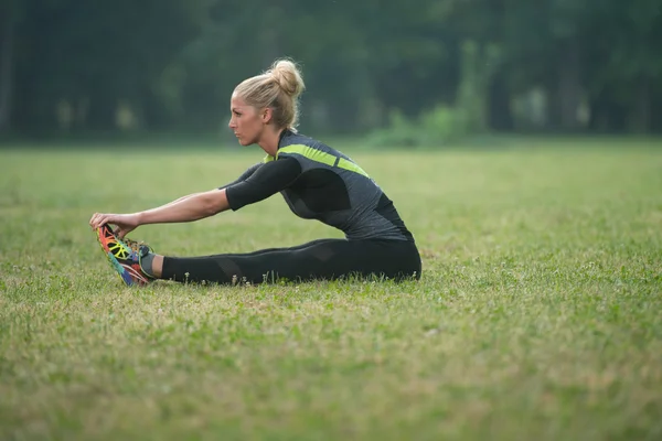 Mujer estirándose en el parque — Foto de Stock