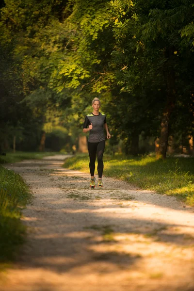 Corredor femenino corriendo durante el entrenamiento al aire libre en el parque —  Fotos de Stock