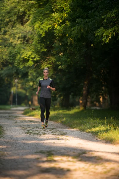 Mujer joven corriendo al aire libre en un día encantador — Foto de Stock