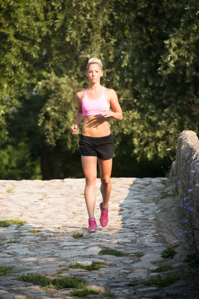 Mujer joven corriendo al aire libre en un día encantador — Foto de Stock