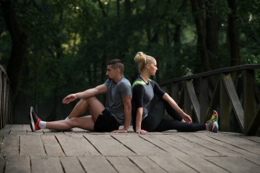 Genç çift ormanlık ormanda çalıştırmadan önce germe