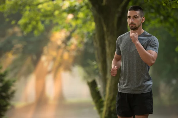 Junger Mann läuft an einem schönen Tag ins Freie — Stockfoto