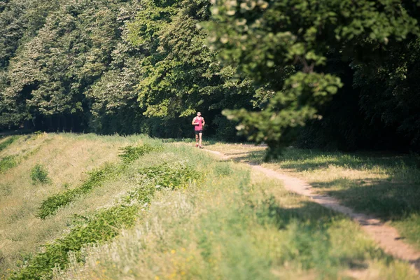 Αθλητής δρομέας τρέχει στο δάσος μονοπάτι — Stockfoto