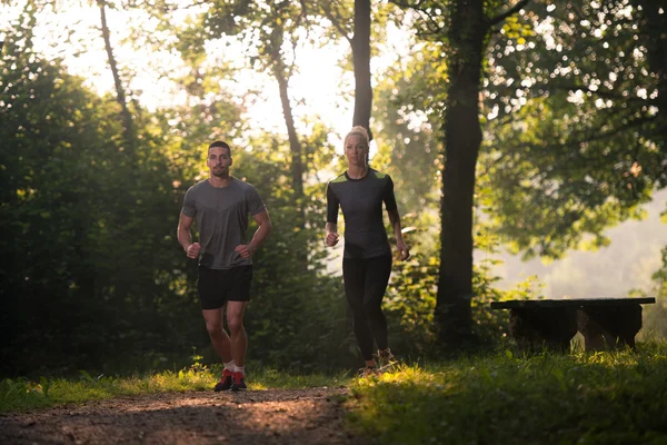 Pareja joven corriendo al aire libre en un día encantador —  Fotos de Stock