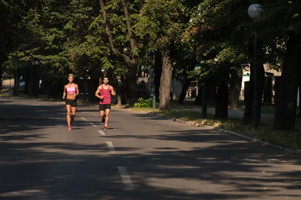 Pareja joven corriendo al aire libre en un día encantador —  Fotos de Stock