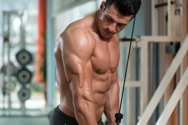 Bodybuilder masculin faisant l'exercice lourd de poids pour des triceps — Photo