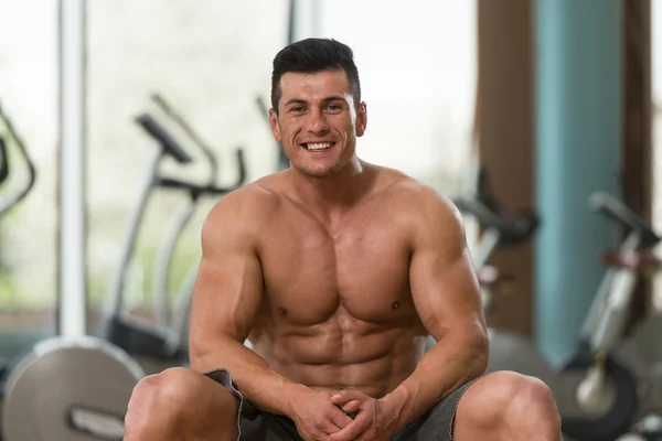 Portret mężczyzny mięśni relaksujący w siłowni — Zdjęcie stockowe