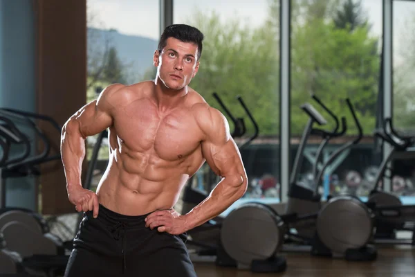 Young Man Stretching Before Exercising In Fitness Center — Stock Photo, Image