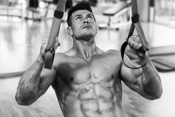 Junger attraktiver Mann trainiert mit trx Fitnessbändern — Stockfoto