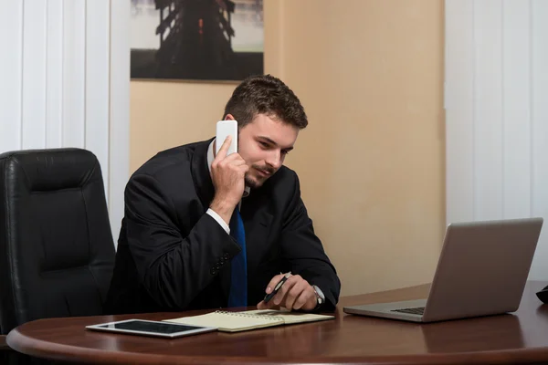 Empresário falando por telefone no escritório — Fotografia de Stock