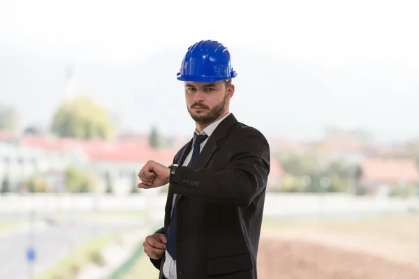 Gerente de construcción guapo mirando su reloj — Foto de Stock