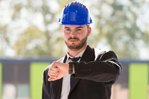 Knappe bouw Manager op zoek op zijn horloge — Stockfoto