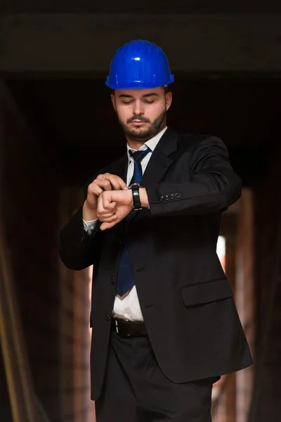 Knappe bouw Manager op zoek op zijn horloge — Stockfoto