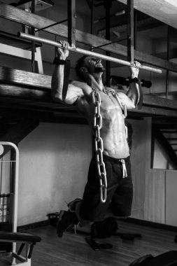 Zincirleri ile sırt egzersizleri yapıyor adam