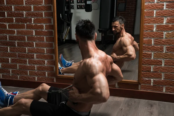 Joven macho haciendo ejercicios de espalda en el gimnasio —  Fotos de Stock