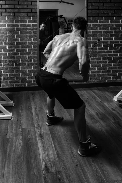 Молодой мужчина делает упражнения для спины в тренажерном зале — стоковое фото