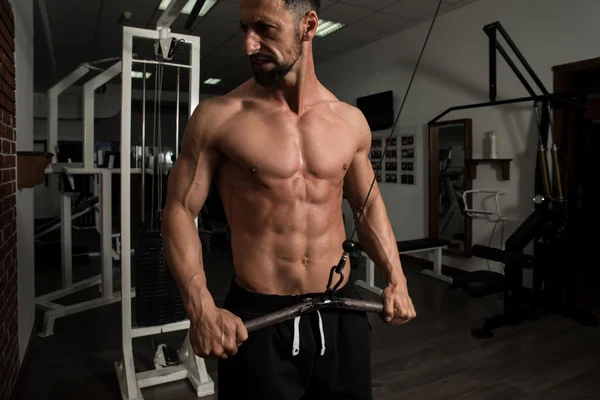 Jovem masculino fazendo exercícios nas costas no ginásio — Fotografia de Stock