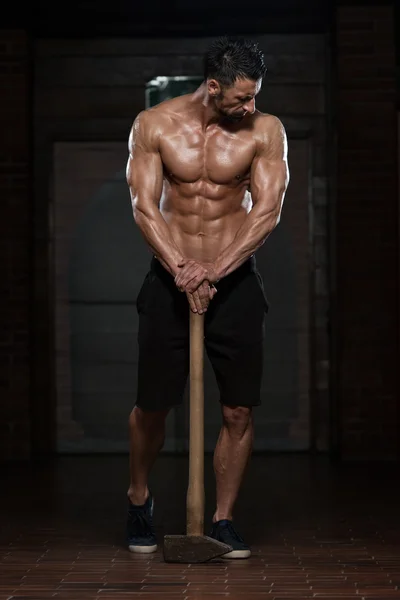 Hombre con martillo mostrando su cuerpo bien entrenado —  Fotos de Stock