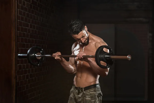 Fisiculturista exercendo bíceps com Barbell — Fotografia de Stock