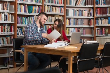 Bir kitaplıkta bir Tablet bilgisayar kullanan öğrenciler
