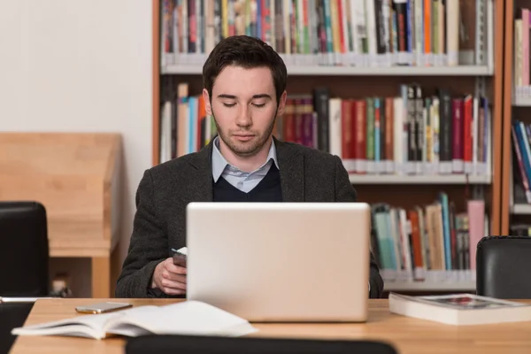 Mahasiswa muda menggunakan Laptop-Nya di Perpustakaan — Stok Foto