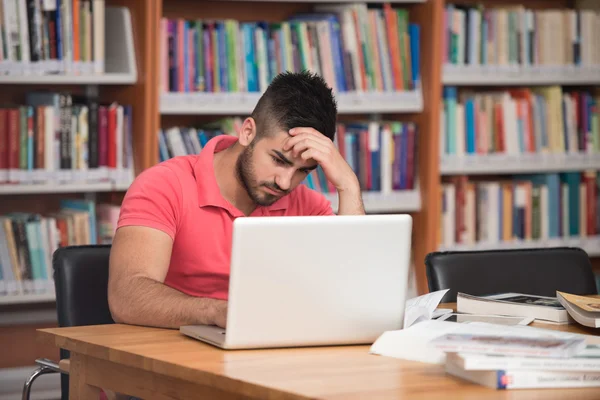 Estudiante masculino confundido leyendo muchos libros para el examen —  Fotos de Stock