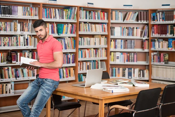 Gelukkig mannelijke Student met boek In bibliotheek — Stockfoto