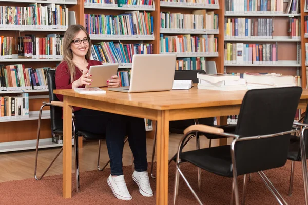 Ung Student med sin Laptop i ett bibliotek — Stockfoto