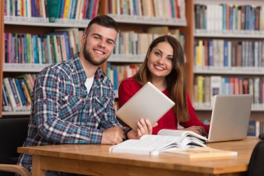 Onların Laptop bir kitaplığı kullanan genç öğrenciler