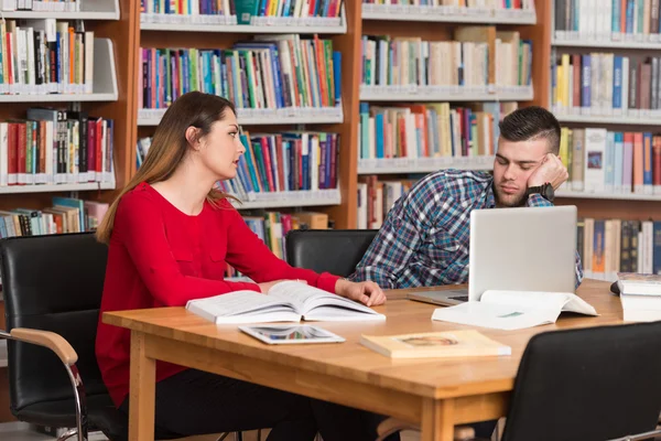 Benadrukt studenten doen hun huiswerk aan de balie — Stockfoto