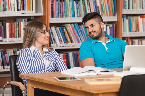 Mladí studenti pomocí jejich notebook v knihovně — Stock fotografie