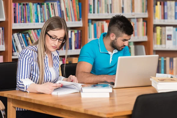 Μαθητούδια χρησιμοποιώντας φορητό υπολογιστή τους σε μια βιβλιοθήκη — Φωτογραφία Αρχείου