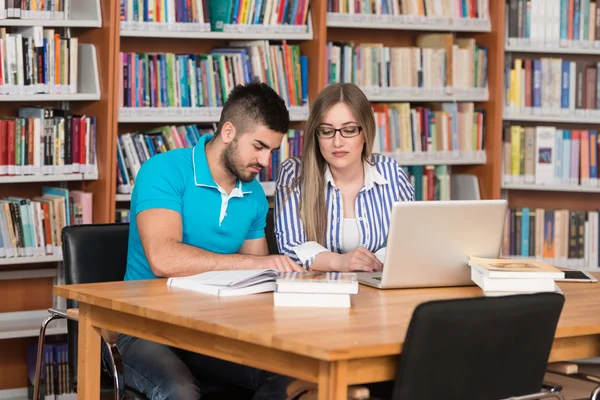 Glada studenter som arbetar med Laptop i biblioteket — Stockfoto