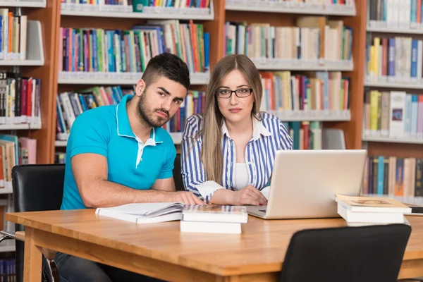 Par elever med Laptop i biblioteket — Stockfoto