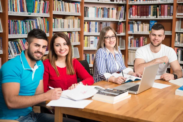 Szczęśliwy studentów z laptopa w bibliotece — Zdjęcie stockowe