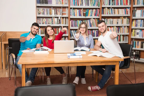Estudantes em uma biblioteca mostrando polegares para cima — Fotografia de Stock