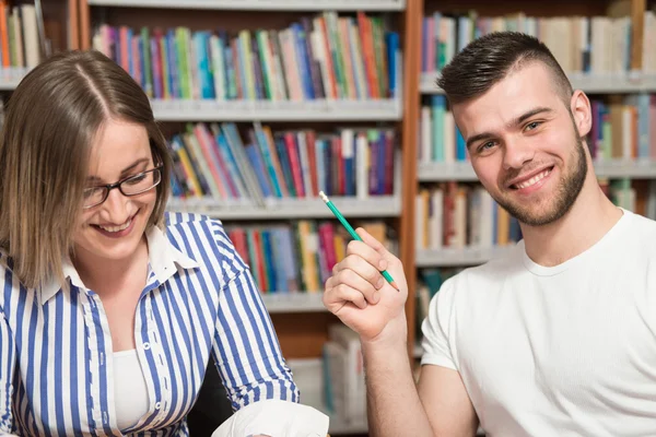 Giovani studenti che utilizzano il loro computer portatile in una biblioteca — Foto Stock