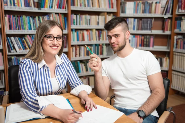 Coppia di studenti con computer portatile in biblioteca — Foto Stock