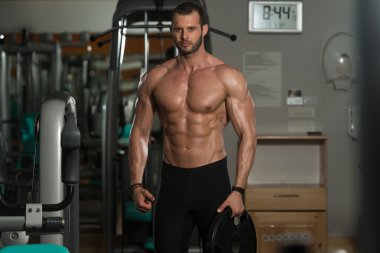 Ağırlıkları elinde tutan adam uygun