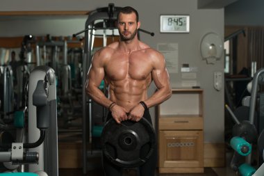 Ağırlıkları elinde tutan vücut geliştirmeci