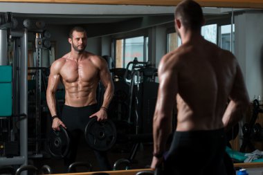 Ağırlıkları elinde tutan adam uygun