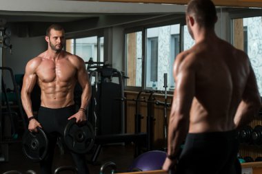 Ağırlıkları elinde tutan vücut geliştirmeci