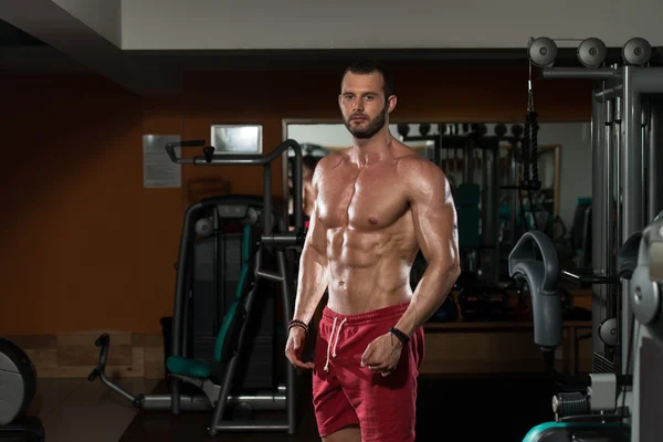 Hombre en el gimnasio mostrando su cuerpo bien entrenado — Foto de Stock