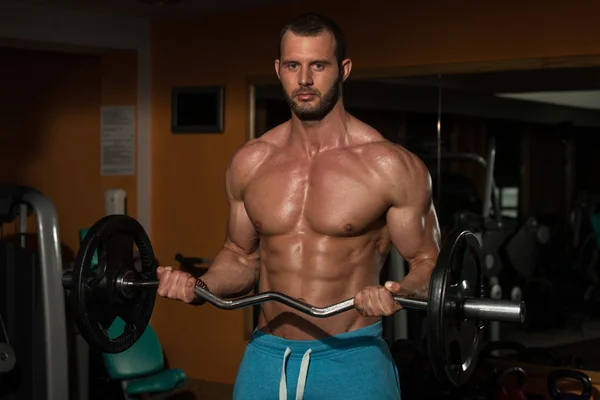 Jovem homem levantando pesos com Barbell — Fotografia de Stock