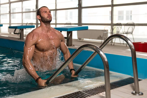 Homme essayant de sortir de la piscine imminente — Photo