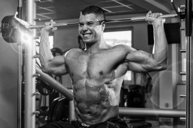 Omuzlar için ağır egzersiz yaparak erkek vücut geliştirmeci