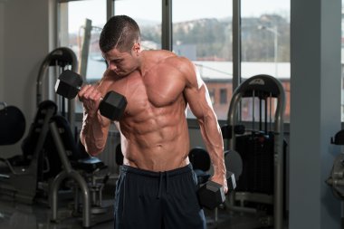 pazı için ağır egzersiz yaparak erkek vücut geliştirmeci