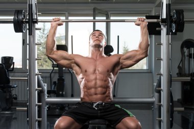 Omuzlar için ağır egzersiz yaparak erkek vücut geliştirmeci