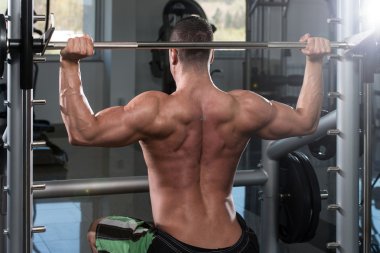 Omuzlar için ağır egzersiz yaparak erkek vücut geliştirmeci
