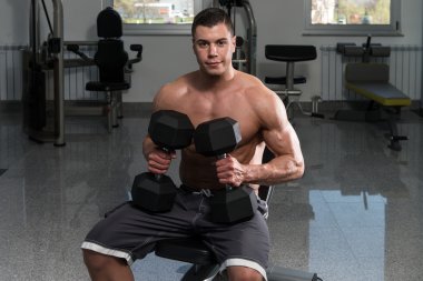 Genç adam dışarı göğüs dumbell ile çalışma